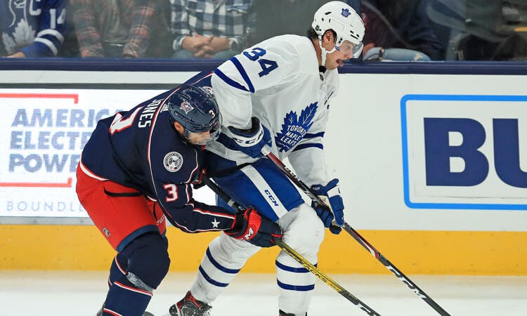 Toronto's Auston Matthews and Seth Jones of the Columbus Blue Jackets battle for the puck in NHL action.