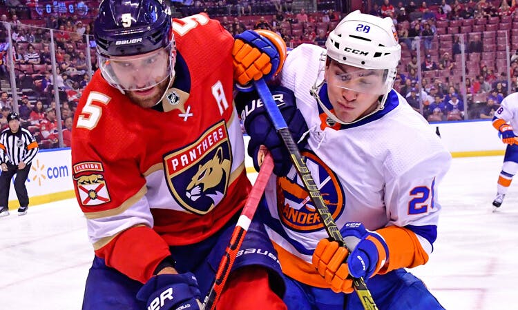 Florida's Aaron Ekblad and Michael Dal Colle of the Islanders battle for the puck in NHL action.