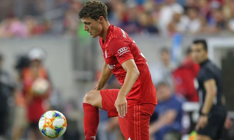 Bayern Munich defender Benjamin Pavard controls the ball during a soccer game.