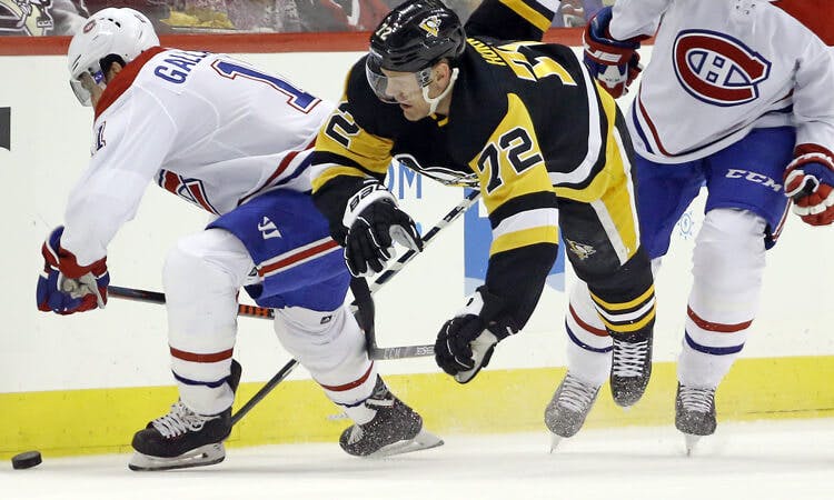 Montreal's Brendan Gallagher and Pittsburgh's Patric Hornqvist battle for the puck in NHL action.