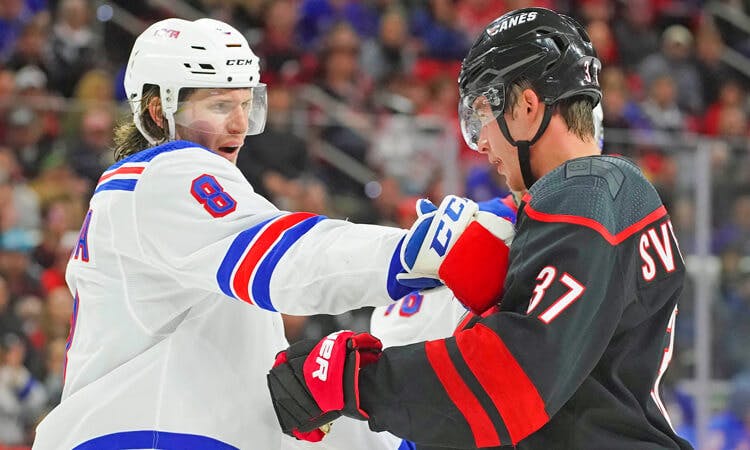 New York Rangers defenseman Jacob Trouba jostles Carolina Hurricanes forward Andrei Svechnikov in NHL action.