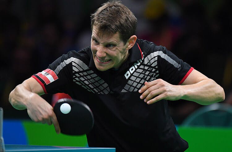 A table tennis player hits a ping pong ball in an ITTF match. 