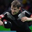 A table tennis player hits a ping pong ball in an ITTF match.